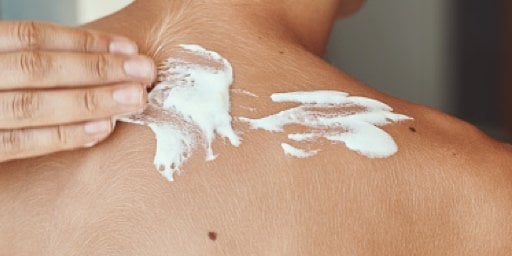 poniendo crema en la espalda